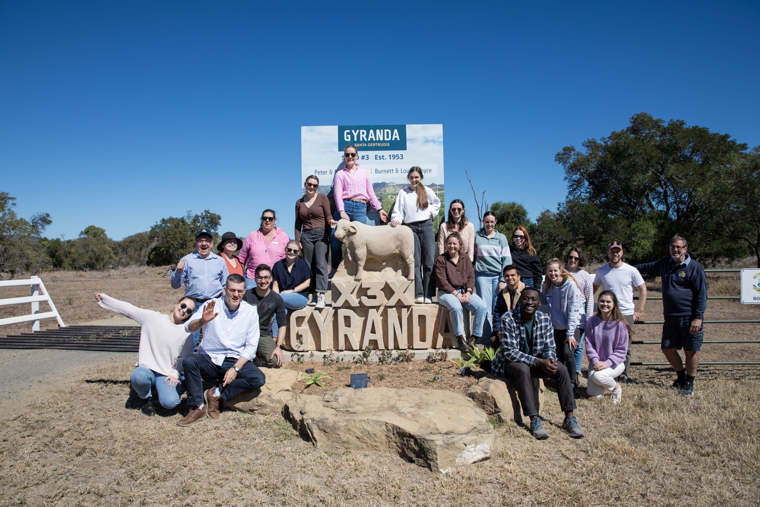 Medical students in front of bull statute and entrance of cattle station in Theodore Queensland