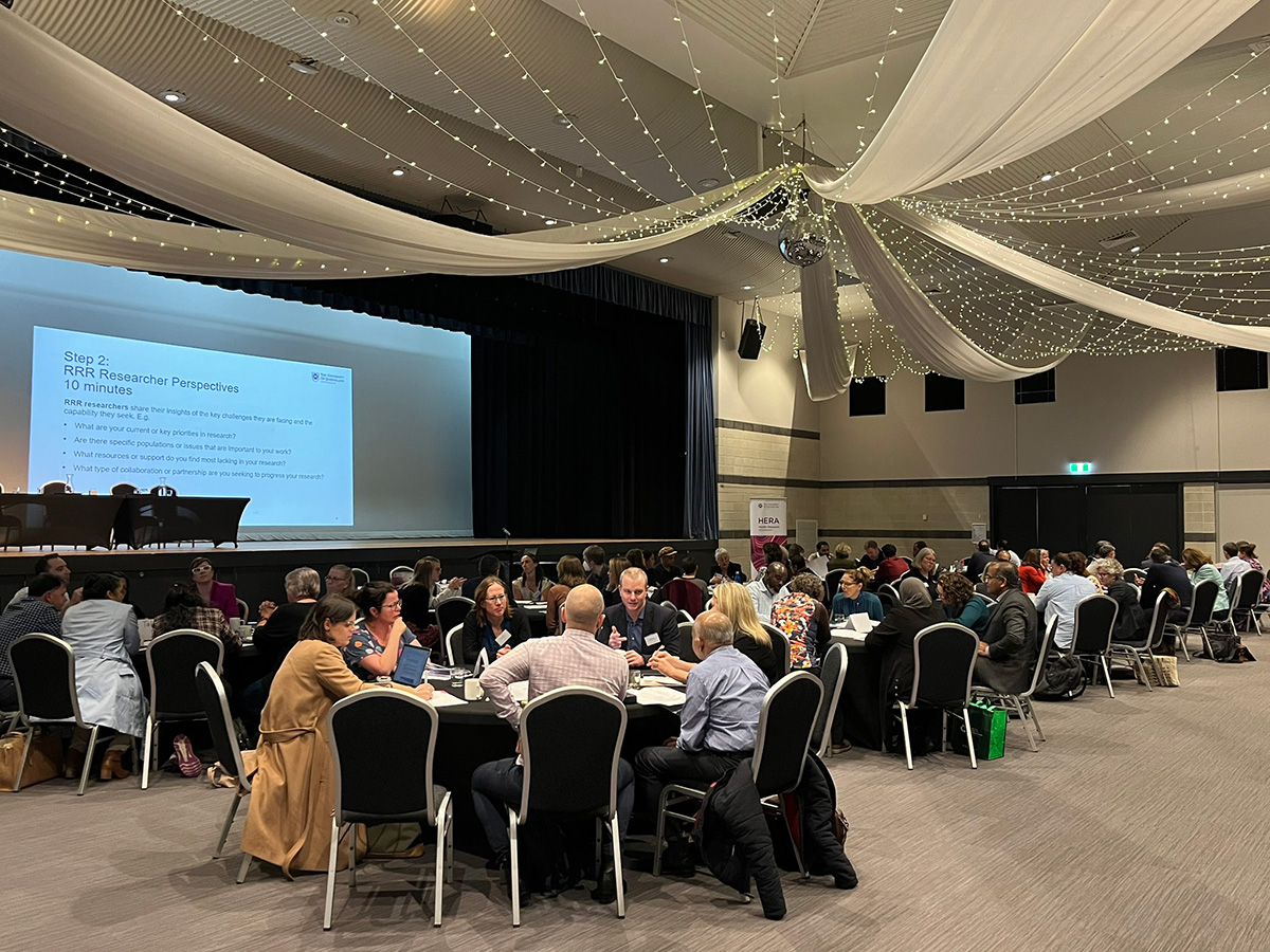 Attendees sitting around tables at the Rural, Regional and Remote (RRR) Health Research Showcase 