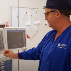 Doctor turning dial on medical equipment