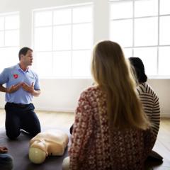 Man in blue shirt showing group of people where heart is