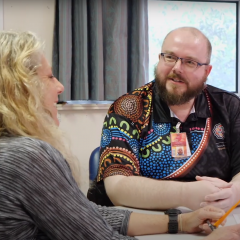 Doctor at table talking to patient