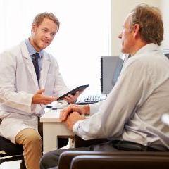 Doctor talking to patient in consult room 