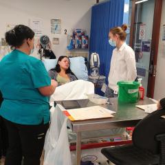 Students in hospital setting talking with patient